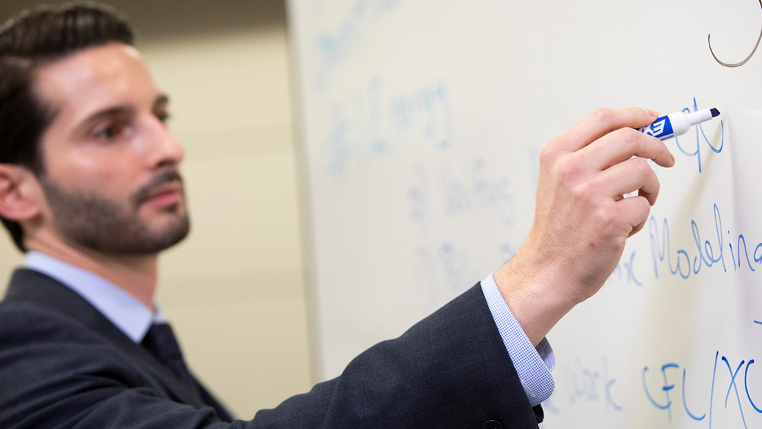 Male Oxy employee writing on whiteboard