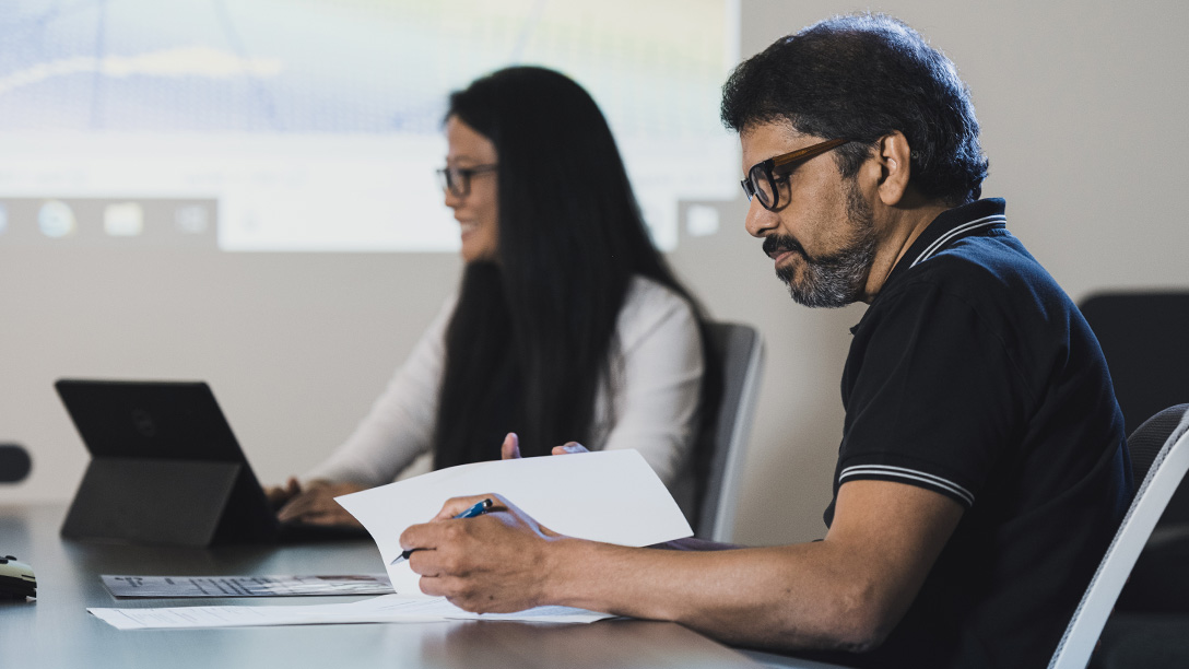 Male and female Oxy employees at conference room table