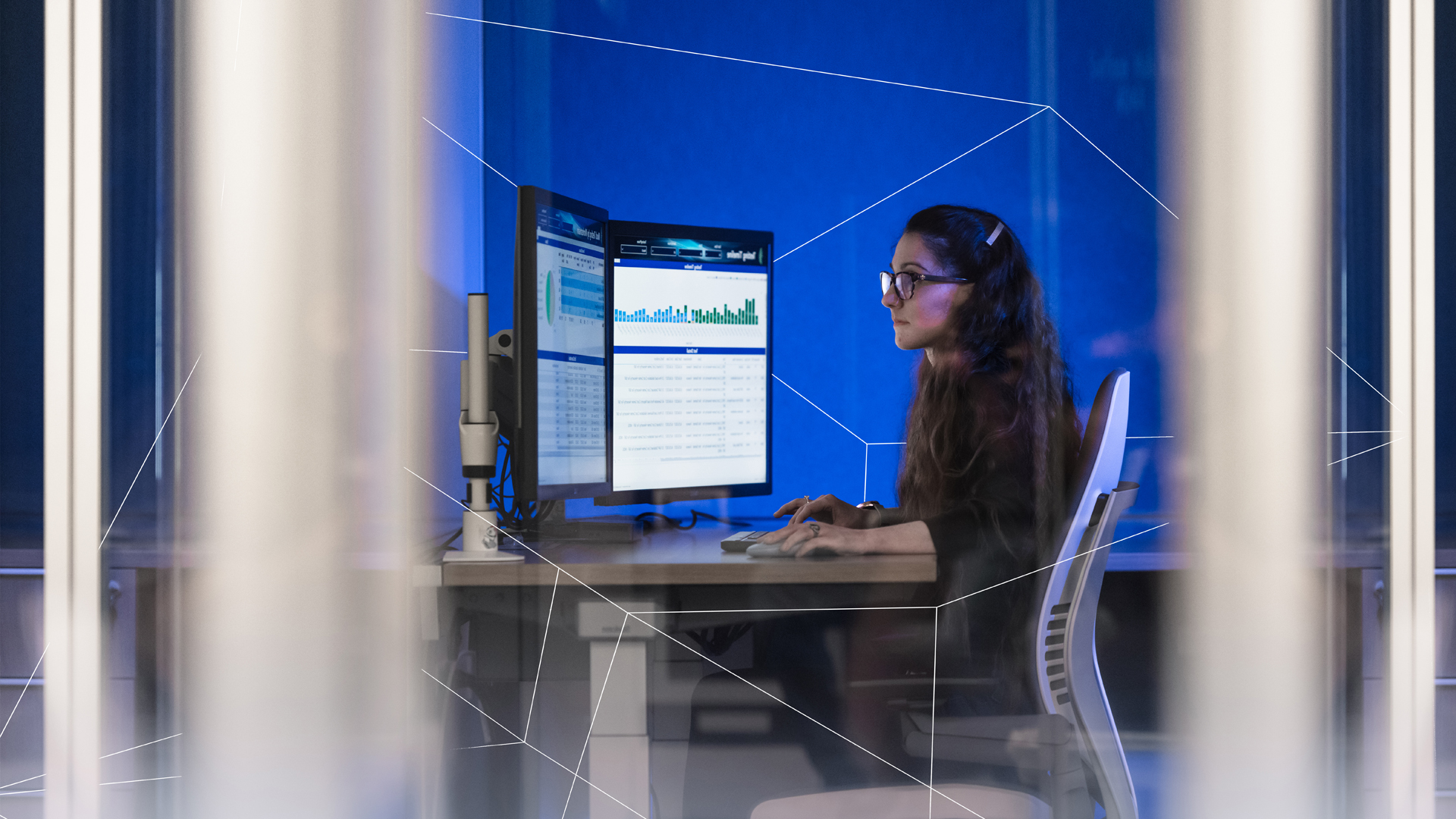 Female Oxy employee working on dual monitors